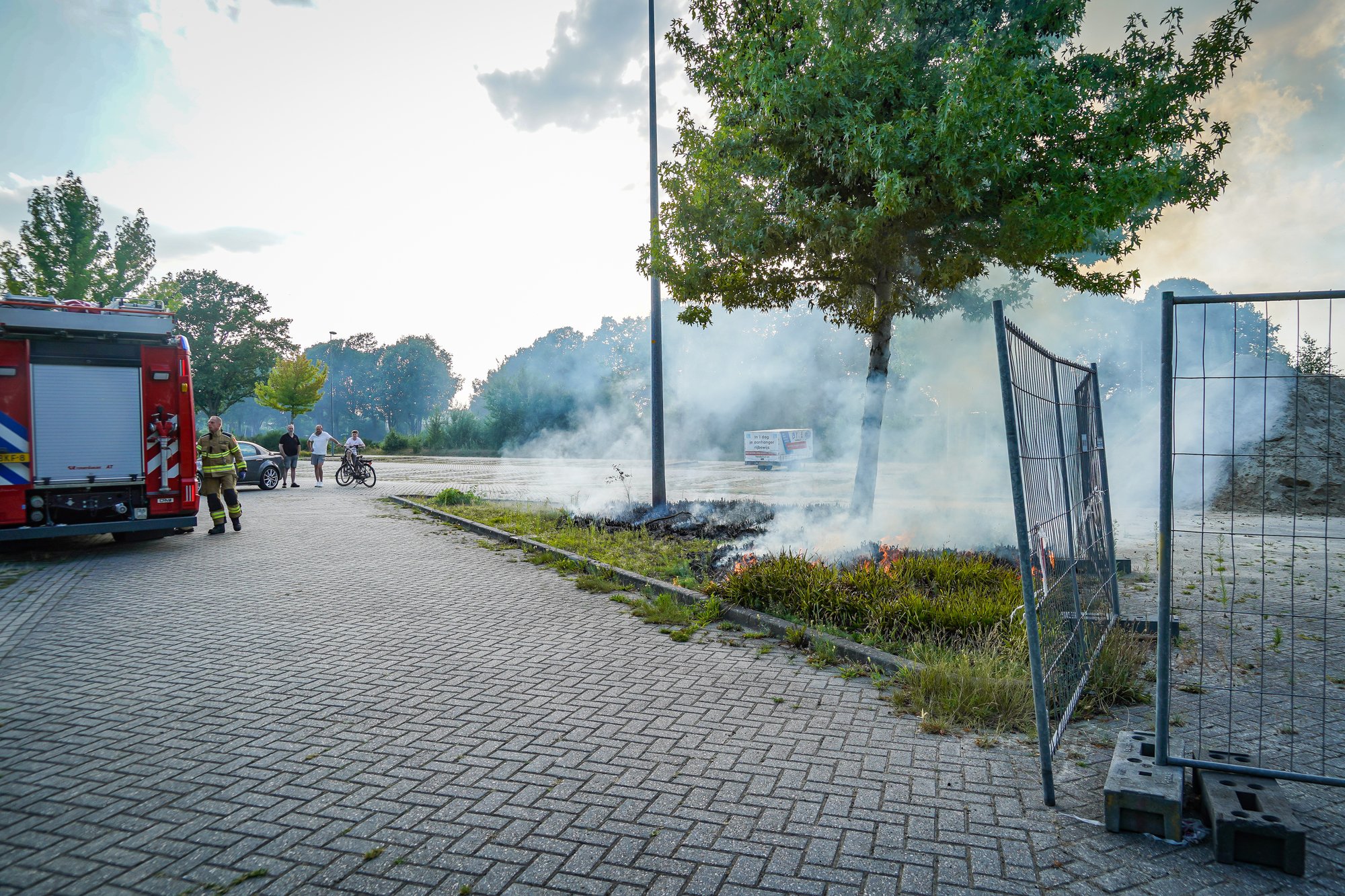 Bosjes bij parkeerplaats in brand aan de Sint Gerardusstraat in Emmen, forse rookontwikkeling zichtbaar